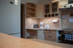 a kitchen with wooden cabinets and a white refrigerator at Apartament w Alejce in Rabka-Zdrój