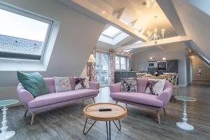 uma sala de estar com duas cadeiras roxas e uma mesa em Hotel TWEED em Sankt Peter-Ording