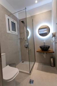 a bathroom with a shower and a toilet and a sink at Gaia Apartments I in Anthoúsa