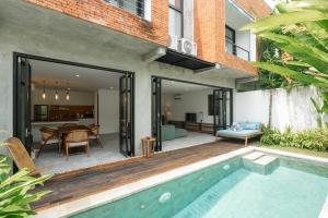 un patio abierto con piscina y una casa en Umalas Living Villa, en Canggu