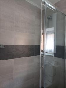 een badkamer met een douche en een glazen deur bij Casa rural en Sariego in Villar