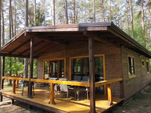 a log cabin with a table in the woods at Osrodek Wypoczynkowy RAJ in Mostowo