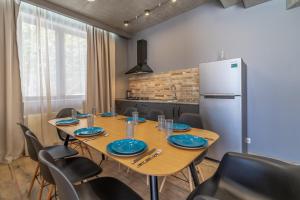 a dining room with a table and a refrigerator at Villa by Sunexpress Bakuriani in Bakuriani