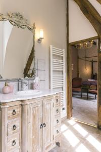 ein Bad mit einem Waschbecken und einem Spiegel in der Unterkunft Maison d'hôtes le Prieuré du Preux 