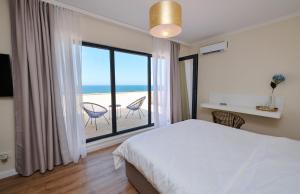 um quarto com uma cama e vista para a praia em Vela Olimp em Olimp