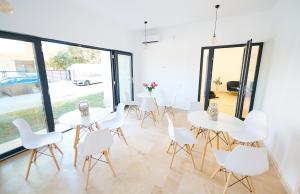 a room with white tables and white chairs and windows at Vela Olimp in Olimp