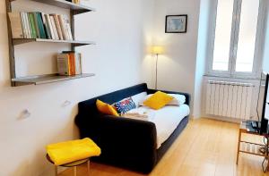 ein Schlafzimmer mit einem schwarzen Sofa und gelben Kissen in der Unterkunft BBHOME Comfort apartment near Colosseum in Rom