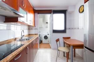 uma pequena cozinha com um lavatório e uma mesa em Casa Enebro em Vélez de Benaudalla