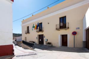 um edifício com bandeiras na lateral em Casa Enebro em Vélez de Benaudalla