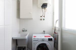 uma lavandaria com uma máquina de lavar roupa e um lavatório em Casa Enebro em Vélez de Benaudalla