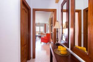 um corredor com uma sala de estar com uma cadeira vermelha em Casa Enebro em Vélez de Benaudalla