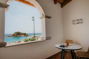 a table in a room with a view of the ocean at Casa Indiana Hotel Boutique in Blanes