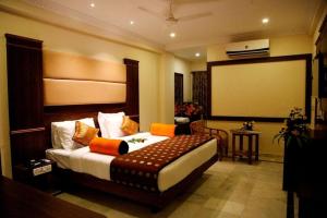 a bedroom with a large bed and a large screen at SET Residency in Kumbakonam