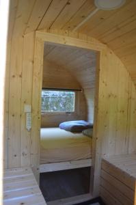 1 dormitorio en una cabaña de madera con 1 cama. en Camping Chon du Tarn en Bédouès