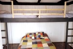 a bedroom with two bunk beds with a quilt at El Racó - Kitesurf Sirena - Cabaña frente al mar in Curanipe