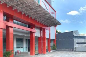 um edifício vermelho e branco com uma escada em Urbanview Hotel Niraz Syariah Banjarmasin by RedDoorz em Sungai Lutus