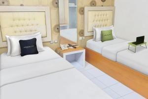 Zimmer mit 2 Betten und einem Laptop auf einem Tisch in der Unterkunft Urbanview Hotel Niraz Syariah Banjarmasin by RedDoorz in Sungai Lutus