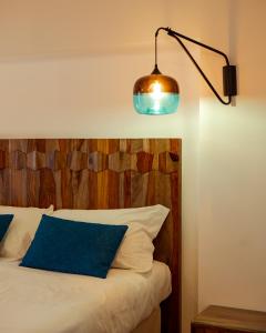 a bedroom with a bed with a wooden headboard and a lamp at Domus Maris Relais Boutique Hotel in Sciacca