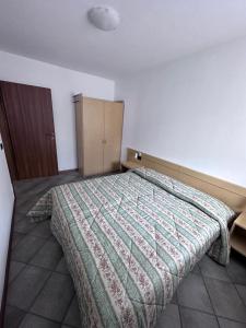 ピンツォーロにあるAppartamenti Vidiのベッドルーム(キルト付きのベッド付)