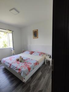 um quarto com uma cama e uma janela em Konavle Village Apartment em Cilipi