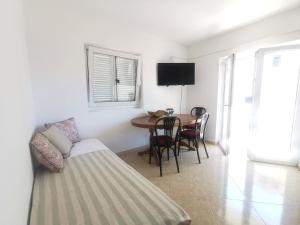 a living room with a couch and a table with chairs at Apartmani Lešić Tribunj in Tribunj