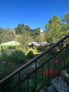 a balcony with a fence and a garden with flowers at GIO-NIKA in Stepantsminda