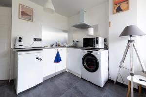 a kitchen with a washing machine and a microwave at Dune Front Paradise - Appartement sur la dune in Soorts-Hossegor