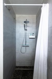 a shower with a shower curtain in a bathroom at Dune Front Paradise - Appartement sur la dune in Soorts-Hossegor +3 photos
