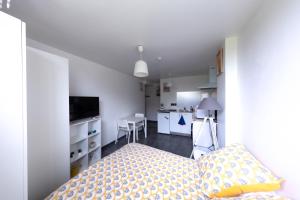 a small bedroom with a bed and a kitchen at Dune Front Paradise - Appartement sur la dune in Soorts-Hossegor
