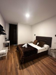 a bedroom with a large bed and wooden floors at Hostal Arenal Madrid in Madrid