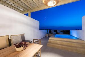 a living room with a table and a swimming pool at Sersi Paros Villas & Suites in Kampos Paros