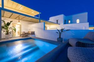 a villa with a swimming pool at night at Sersi Paros Villas & Suites in Kampos Paros