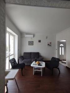 - un salon avec un canapé et une table dans l'établissement Konavle Village Apartment, à Čilipi