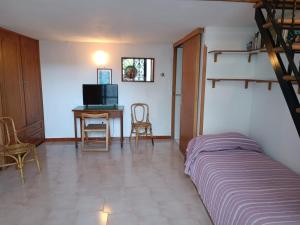 a bedroom with a bed and a table with a television at la Dacia di Gina in Ravello