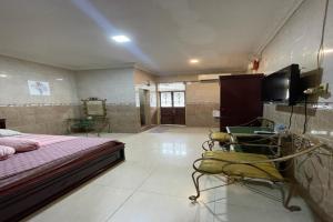 een slaapkamer met een bed, een tv en een stoel bij OYO 92772 Losmen Diah Syariah in Langsa