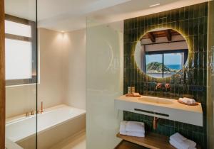 a bathroom with a sink and a tub and a mirror at Casa Indiana Hotel Boutique in Blanes