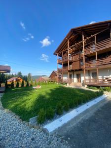 a house with a green lawn in front of it at Бо&Не in Yablunytsya