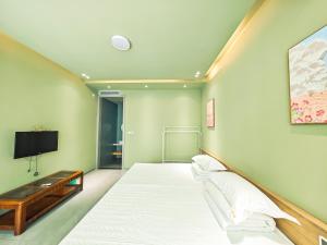 a bedroom with a large bed and a tv at Yue Tong Farmer House in Huairou