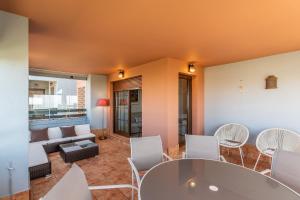 a living room with a table and chairs and a couch at Las Palmeras by Ĥ - Playa Punta del Moral PLHP28P11 in Isla del Moral