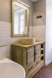 bagno con lavandino e specchio di Maison d'hôtes le Prieuré du Preux 