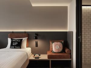 a bedroom with a bed and a table with a clock at Moxy Belgrade in Belgrade