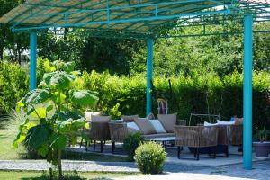 uma pérgola com cadeiras e um sofá num jardim em Wait`N Sea House em Tuzla