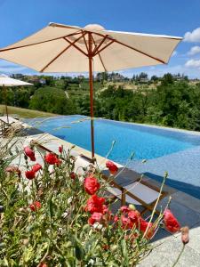 um guarda-sol e uma cadeira ao lado de uma piscina em Cascina Gazzeri Country House em Tagliolo Monferrato