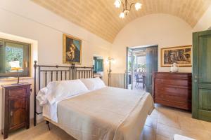 ein Schlafzimmer mit einem großen Bett, einer Kommode und einem Fenster in der Unterkunft Tenuta Rifugio Alisha in Locorotondo