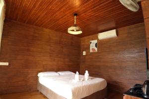 1 dormitorio con 1 cama en una pared de madera en Mazhavilkadu ForestResort & Restaurant, en Kozhikode