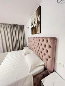 um quarto com uma cama grande e uma cabeceira acolchoada em Wait`N Sea House em Tuzla