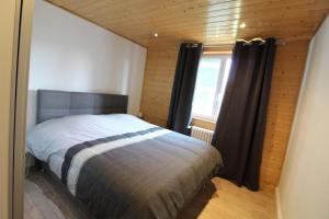 a bedroom with a bed in a room with a window at Apt 1er étage Chalet Au coteau des xette in Gérardmer