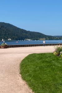 a person walking on a beach near a body of water at Apt 1er étage Chalet Au coteau des xette in Gérardmer