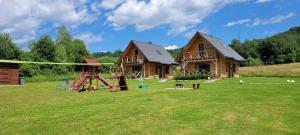 einen Spielplatz vor einem Blockhaus in der Unterkunft Domki w Bieszczadach in Ustrzyki Dolne