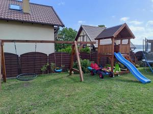 a playground with a slide and a swing set at Apartament Nad Jeziorem Ewa in Nadole